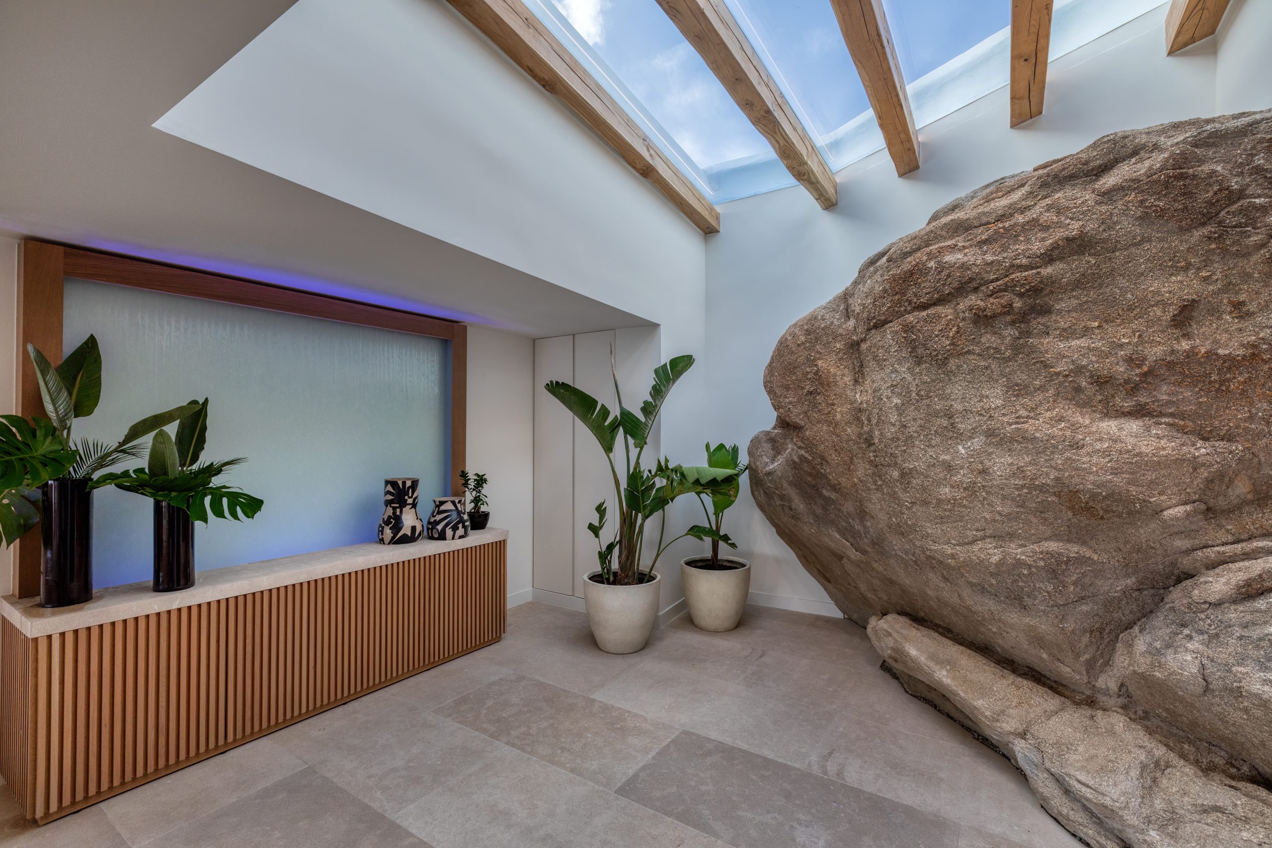 Natural rock integrated into the light-filled interiors of Lithos Residence