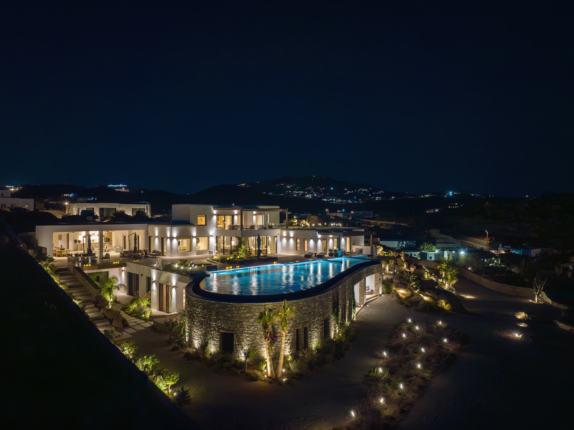 Lithos Residence and its pool illuminated at night